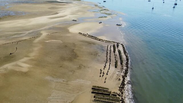 Ria Formosa riverbed at low tide, with shellfish production and yachts anchored in the river in Algarve, Portugal