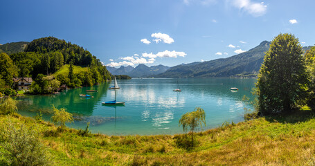 Naklejka premium Lake Wolfgangsee with sailing boats, sailboat anchored in a calm lake bay, Alps, Austria