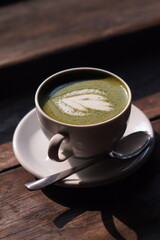 Hot Matcha Drink on wooden table background