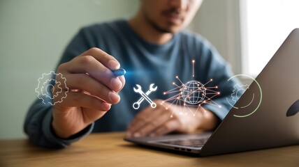 Man using stylus on laptop with glowing engineering and technology icons tools wrench