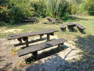 Fototapeta premium Outdoor Wooden Benches and Tables in Sunlight