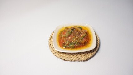 A delicious plate of spicy, flavorful food with a rich sauce, perfect for showcasing vibrant, home-cooked meals in a rustic setting.