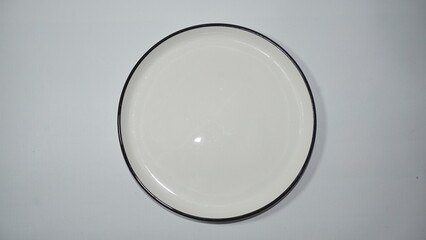 A simple, elegant round plate with a sleek black rim, perfect for showcasing delicious dishes in a minimalist setting. Ideal for food photography and tableware collections.