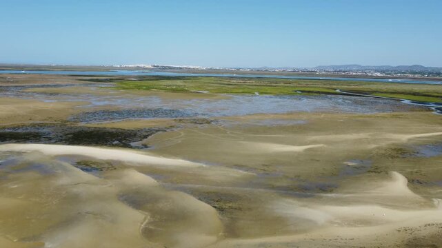 Ria Formosa with riverbed exposed at low tide and Faro in the background on Algarve in Portugal