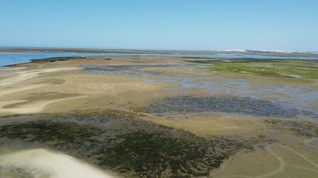 Ria Formosa with riverbed exposed at low tide and Faro in the background on Algarve in Portugal