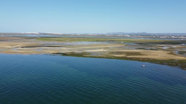 Ria Formosa with riverbed exposed at low tide and Faro in the background on Algarve in Portugal