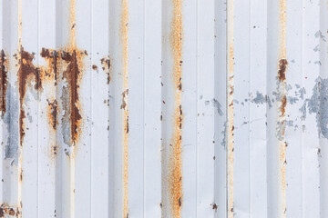 Aged white painted corrugated metal wall with rust and scratches 
