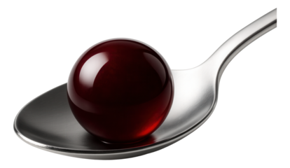 A perfectly round bead of red wine reduction, centered on a silver spoon.