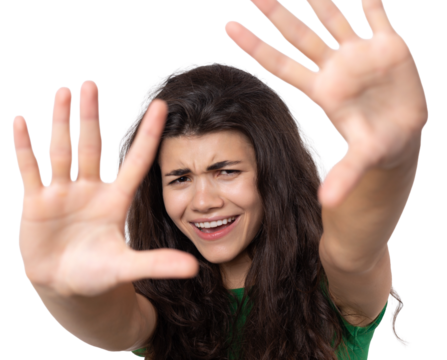 Portrait of a serious young woman showing stop gesture with her palm over white background
