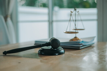 A wooden gavel rests on a stack of documents beside a laptop, symbolizing power and justice.