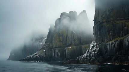 Fog rolling into rugged northern fjord coastline