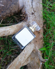 Perfume bottle mockup with plain white label on the wood nature background