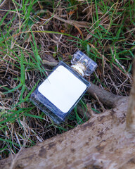Perfume bottle mockup with plain white label on the nature background