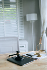 A wooden gavel rests on a stack of documents beside a laptop, symbolizing power and justice.