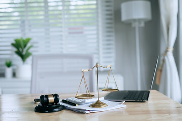 A wooden gavel rests on a stack of documents beside a laptop, symbolizing power and justice.