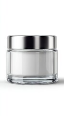 Cylindrical glass jar with a silver lid, containing white cream, isolated on a white background