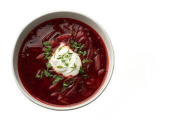 A bowl of borscht with a dollop of sour cream and parsley on a white background view from above