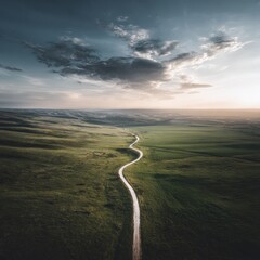Winding road through a grassy valley at sunset