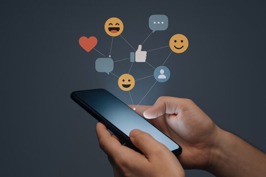 Smartphone Connection: Person Using Social Media on a Mobile Device with Emoticons and Engagement Icons