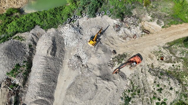Excavator , diggers Overhead birds eye drone aerial view  in quarry Essex UK