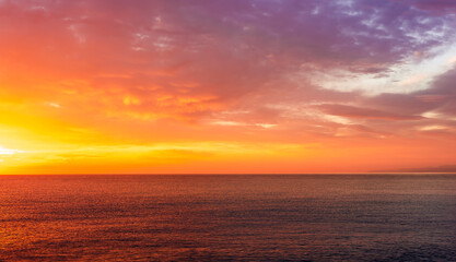 Obraz premium beautiful sunrise or sunset seascape with amazing calm sea water with waves and colorful amazing cloudy morning sky on background