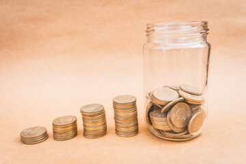 Glass jar filled with coins with a yellow lid and coin growth with a solid bottom