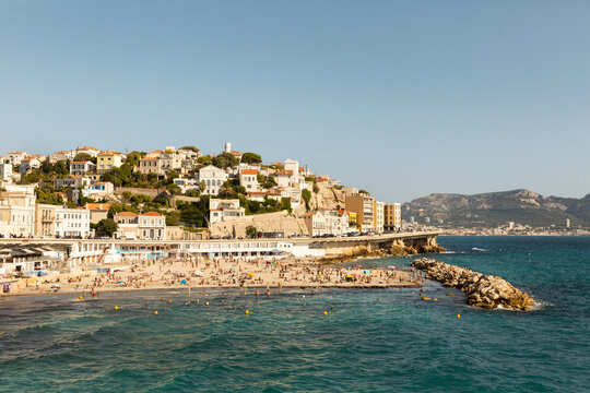 Vue sur la plage du Proph&egrave;te de la ville de Marseille avec des baigneurs en &eacute;t&eacute;, quartier du Roucas-Blanc, corniche Kennedy et ciel bleu en arri&egrave;re plan, Marseille, Sud de la France
