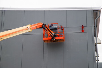 Elevated pedestrian overground crossing tunnel facade painting using a telescopic boom lift with a basket © Rangsarit