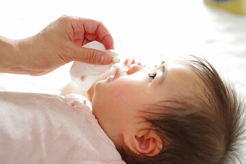 優しく赤ちゃんの顔を拭くママの手元