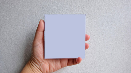 Woman hand holding blank white notepaper on over white background