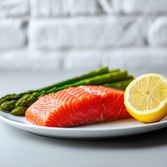 Fresh salmon fillet with asparagus and lemon on a white plate