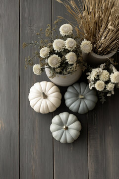 Minimalist fall flat lay with white and sage pumpkins on grey wooden floor, top view