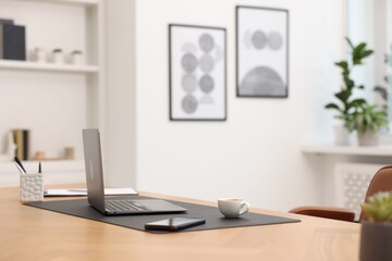 Stylish workplace with modern laptop and stationery on wooden desk indoors