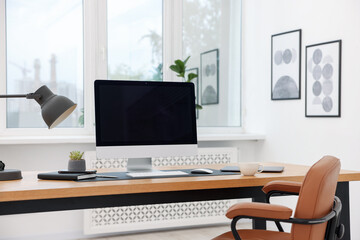 Stylish workplace with modern computer and stationery on wooden desk indoors