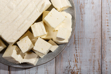 Brynza cheese , soft sheep's cheese bryndza on gray plate on wooden background. Top view, copy space.