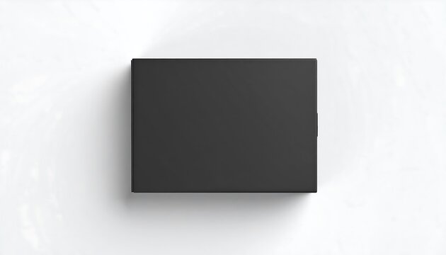 Top down view of a closed matte black rectangular box on a white surface with a soft shadow