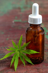 Natural extract bottle with cannabis leaf on table