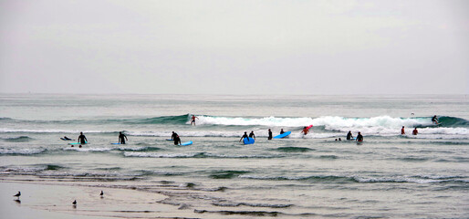 Surfers at a Santa Barbara California beach on a foggy day