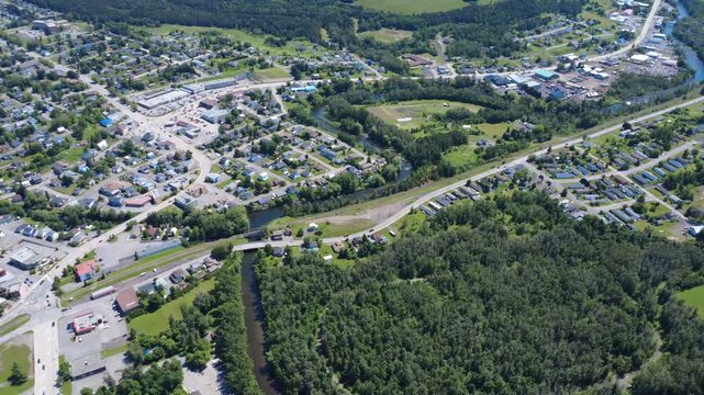 Panoramic aerial view of the city of Amqui and the cars bustling like ants on the roads at the source of the Matapedia River, Matapedia Valley, Quebec, Canada.