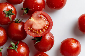 Fresh cherry tomatoes with one juicy half on white background
