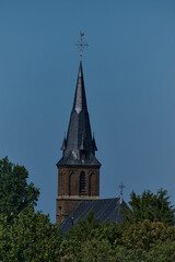 Kirchturm im Sommer vor blauem wolkenlosem Himmel