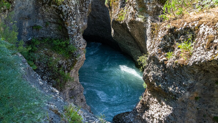 a river in a stone canyon. a river in the mountains