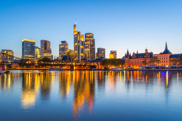 Fototapeta premium Illuminated Frankfurt City Downtown Skyscrapers at Evening Twilight and Reflection in Main River. Blue Hour. Hesse, Germany