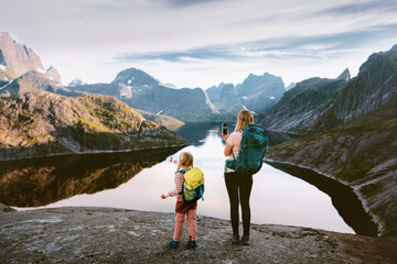 Family mom and child hiking in Norway travel in Lofoten islands woman taking photo using smartphone mountains and lake view, active vacations navigation application technology camping trip outdoor