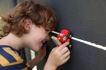 Little boy playing with toy car outdoors © New Africa