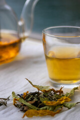 Medicinal herbs in the foreground next to an herbal infusion. Blurred background..deal for promoting mental clarity and calm.