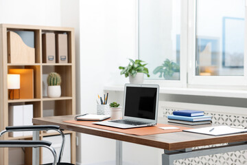 Stylish workplace with modern laptop and stationery on wooden desk indoors