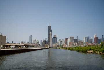 Naklejka premium Skyline view of Chicago along the river on a bright sunny day with clear blue skies and reflections on the water