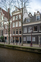 Charming canal houses along the waterways of Amsterdam featuring traditional architecture and serene reflections on a calm day
