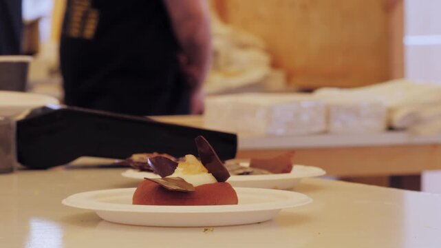 Mousse orange cake, creamy dessert close-up. Almond dacquoise, raspberry confit, crispy layer with caramelized hazelnuts and raspberry powder, mousse based on bitter chocolate.